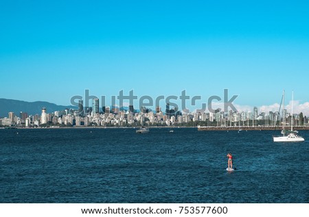 A paddle boarder takes in the Summer view of downtown Vancouver from Jericho beach in Vancouver, British Columbia, Canada.