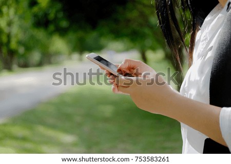 Asian woman using smartphone in park