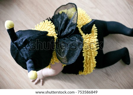 cute baby in a bumble bee costume crawling on the floor