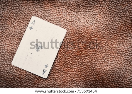 Hand holding old playing cards on brown leather background