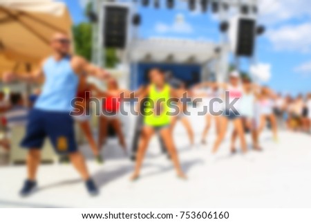 Blurred for background. afternoon dance show during beach party in luxury complex. Young men, women and children participating in Resources Dance show during party under scorching sun.