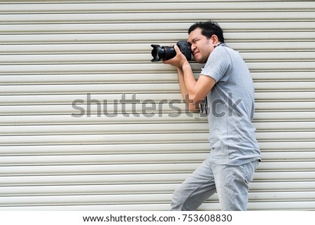 Photographer  man young shooting have fun on steel sheets background.
