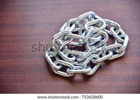 Pile of Metal Chain Isolated on Wooden Table