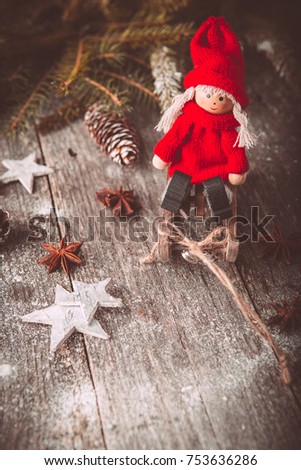 Xmas or new year composition with holiday decoration - sledge, little man figures and fir branches, pinecones on wooden background. Xmas card. Space for text. Vintage style. Toned picture by Instagram