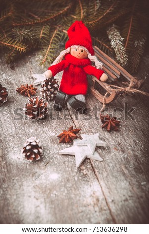 Xmas or new year composition with holiday decoration - sledge, little man figures and fir branches, pinecones on wooden background. Xmas card. Space for text, Vintage style. Toned picture by Instagram