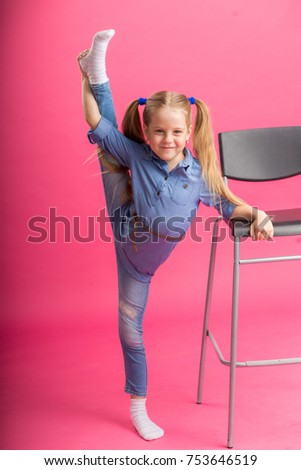 Beautiful girl stretch exercising on pink background in studio.