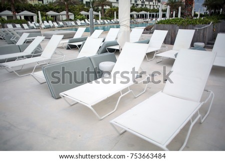 White Deck Chairs at Tropical Resort Pool in Summer