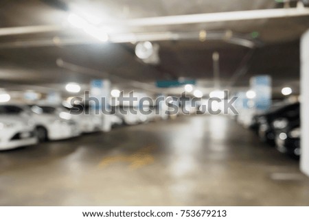 blur many cars in car parking lot inside shopping mall building