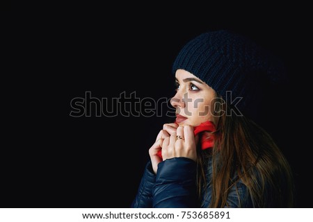 winter portrait of young woman on dark background. Young woman in hat