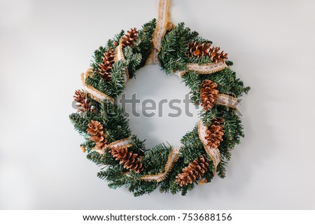 Handmade christmas wreath hanging on the white wall
