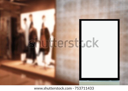 vertical advertising billboard or blank showcase light box for your text message or media content in front of fashion women clothes shop showcase in shopping mall, sale, commercial and marketing