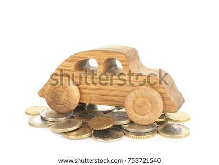 Wooden toy car and pile of coins on white background. Buying car concept