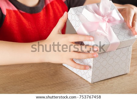 The girls' hands open the gift for a moment