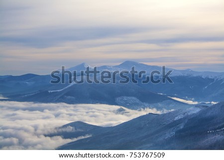 Fantastic winter landscape which including of copy-space for text. Mountains above the clouds. Ski resort Dragobrat, Carpathian mountains, Ukraine.