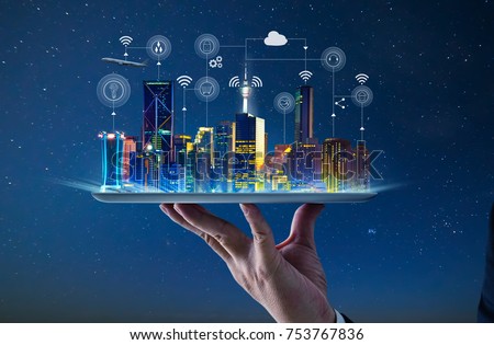 Waiter hand holding an empty digital tablet with Smart city with smart services and icons, internet of things, networks and augmented reality concept , night scene . Royalty-Free Stock Photo #753767836