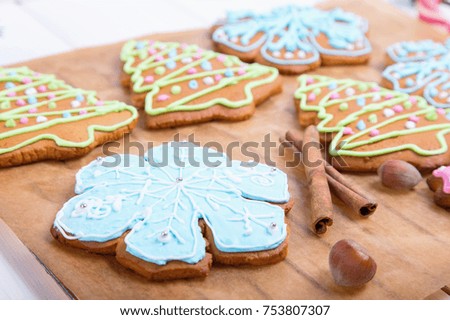 Christmas cookies, decorated sugar and gingerbread in tree and snowflake shapes. Delicious colorful Christmas cookie with festive decoration with light blue and white.