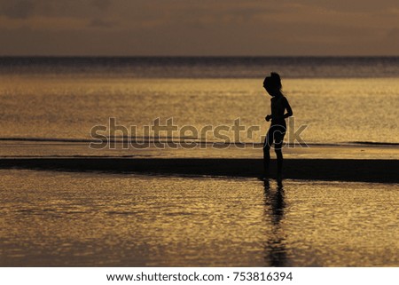 the silhouette photo of a girl enjoying on the beach in sunrise