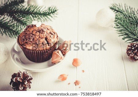Chocolate muffin and branches fir on white wooden background. Selective Focus. Copy space. Vintage stile. Toned image