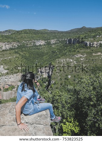 Young woman sitting on edge above the valley  ( contemplating )