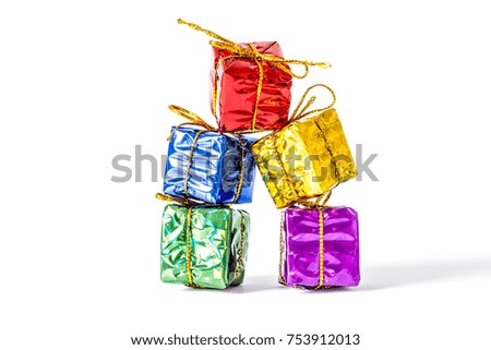 Gifts boxes  in a multi-colored package bandaged with a bow stand in a column close-up isolated on white background