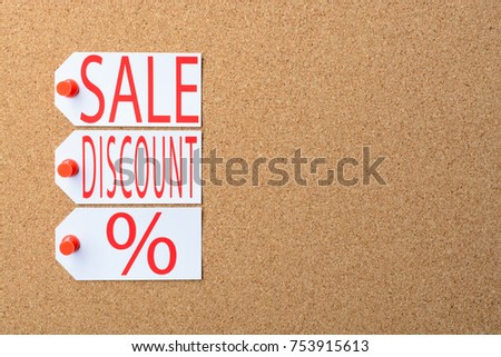 Tags with the word SALE pinned to a cork Board