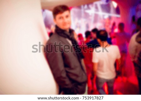 Blurred for background. night club party. People smiling and posing on cam during concert in night club party. Man and woman have fun at club. Boy and girl at night club party