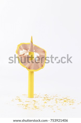 Creative design concept with yellow color pencil with pencil shaving isolated on white background