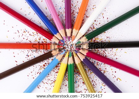 Creative design concept with bunch of different color pencils with pencil shaving isolated on white background
