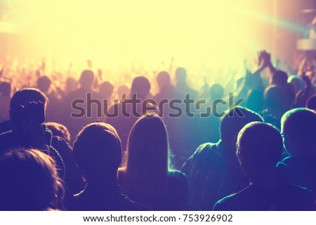 The audience watching the concert on stage in big concert club.