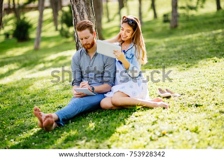 Beautiful couple studying together for exams in nature