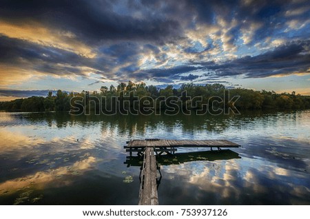 Evening sky with clouds reflected in the calm water of a picture