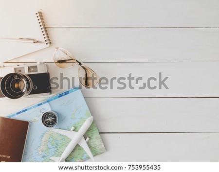 top view travel concept with retro camera, smartphone, map and Outfit of traveler on white table wooden background with copy space, Tourist essentials.