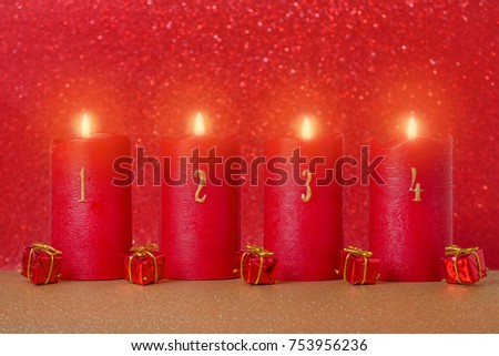 traditional advent candles with numbers and gifts on red background, selective focus