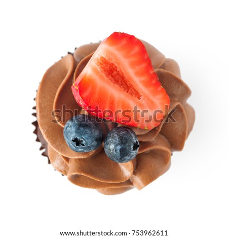 Chocolate cupcake with whipped chocolate cream, decorated fresh strawberry, blueberry isolated. Picture for a menu or a confectionery catalog. Top view.