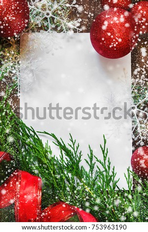Christmas decoration decorations, bows, ribbons, fir branches, Christmas balls on a wooden background with copy space for text, messages on white sheet, festive mood and atmosphere  imitation  snow