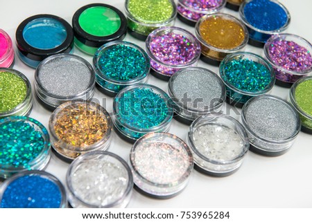 Set of sparkling glitters in jars, selective focus, isolated on white background