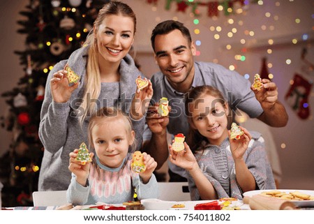 Picture showing happy family preparing Christmas biscuits