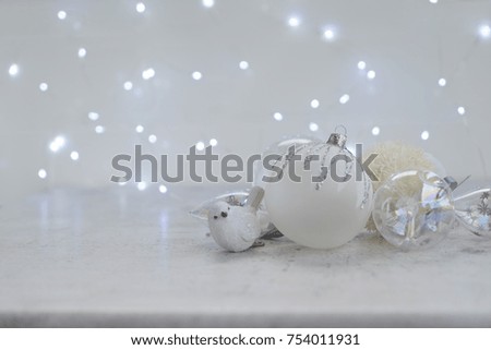 White winter christmas scene with glass ball and bird decorations with copy space, christmas bokeh lights in background