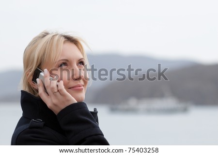 happy girl talking over the cellphone at the seashore