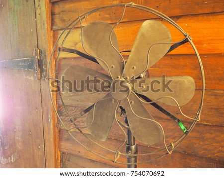 Old retro rusty grunge metal blades portable fan in vintage style photo.