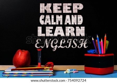 Motivation text Keep calm and learn English on school black chalkboard with school accessories