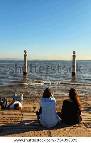 Tourists on the banks of Tagus river in Lisbon