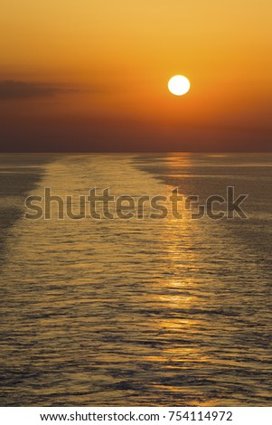 Landscape of a large boat wake on the ocean at sunset