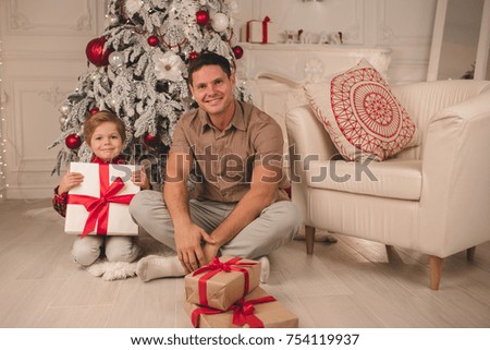 Father and son unwrapping presents on Christmas evening