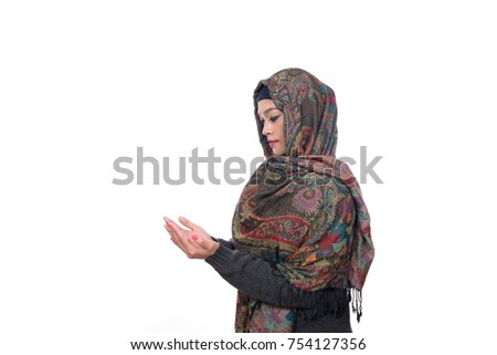 Young asian muslim woman in head scarf smile with arms crossed praying with her hand isolated on white background.