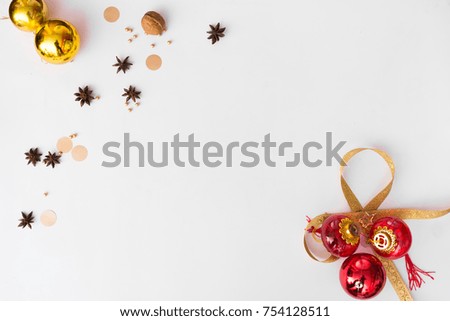 Top view on nice Christmas gift wrapped in white gift paper, Christmas tree decorations on white wooden background with sparkling stars. New Year