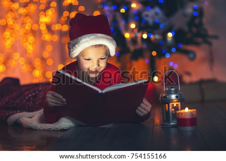 Surprised child opening magic Christmas book. Xmas holiday concept