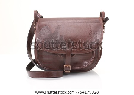 Leather hunting bag with brown ornament with patronage on white isolated background.