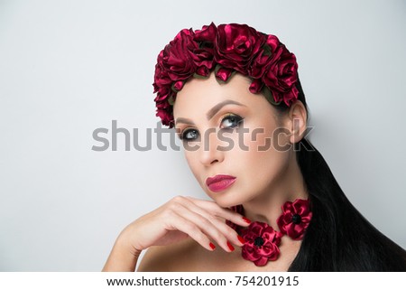 Young beautiful girl lady model with a fashionable flower tiara. professional make-up arrows eye shadows long lashes, stylish matte vine lips marsala color. new horizontal photo banner grey background