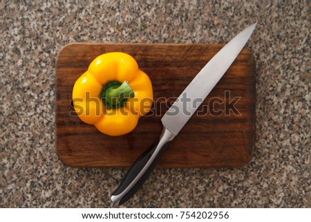 Ripe yellow pepper in wood cutting board